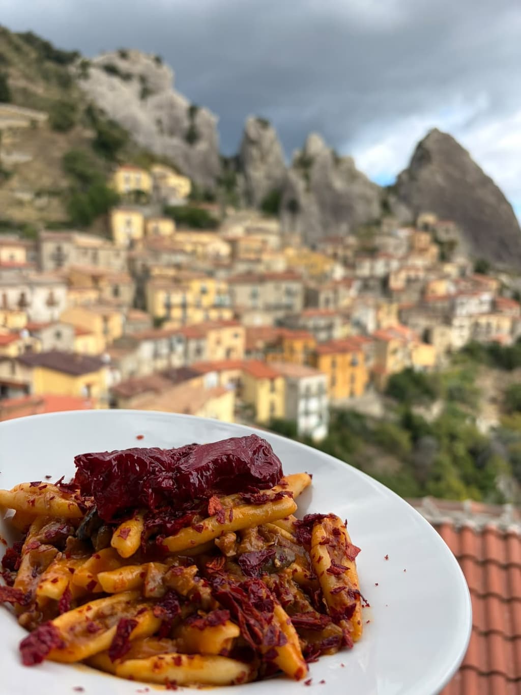 Strascinati con salsiccia, funghi cardoncelli e peperoni cruschi, con il paese di Castelmezzano e le guglie sullo sfondo.